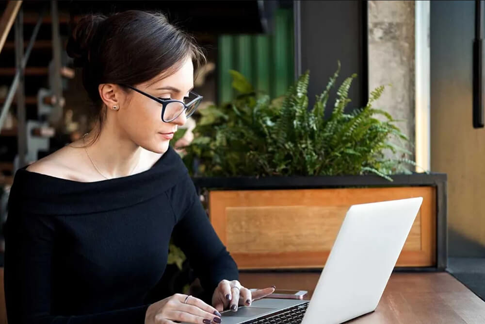 Девушка работает за ноутбуком Девушка работает за ноутбуком