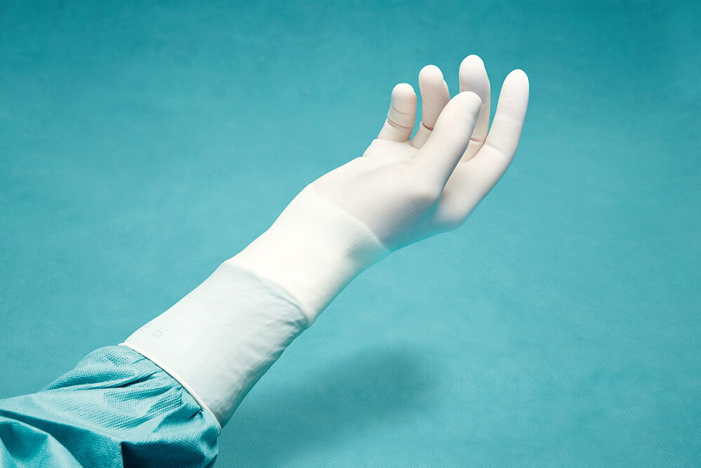 Хирург в стерильных опудренных перчатках Хирург в стерильных опудренных перчатках