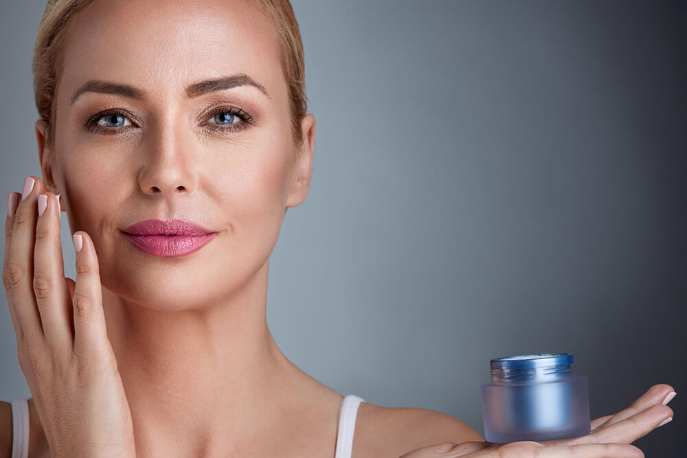 Женщина пользуется антивозрастной косметикой Женщина пользуется антивозрастной косметикой